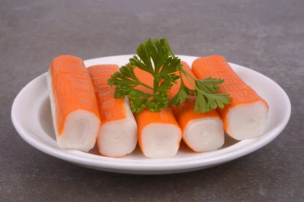 Surimi Kije Spodku Gałązką Pietruszki Zbliżenie Szarym Tle — Zdjęcie stockowe