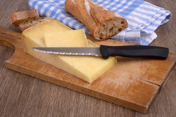 Kawałki Sera Laguiole Nożem Desce Krojenia Obok Kawałka Chleba Bliska — Zdjęcie stockowe