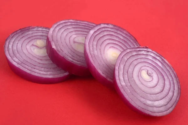 Rote Zwiebelringe Nahaufnahme Auf Rotem Hintergrund Geschnitten — Stockfoto