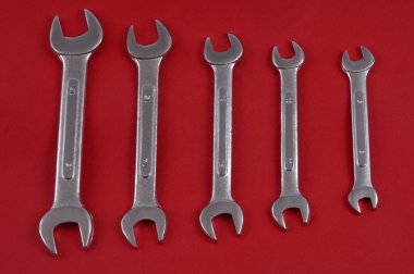 Flat wrenches of different sizes close-up on red background
