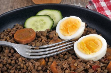 Havuç dilimli mercimek tabağı, salatalık ve yakın plan çatallı haşlanmış yumurta.