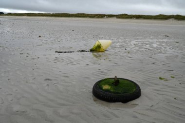 Lampaul-Ploudalmezeau, Brittany 'deki Trois Moutons plajında şamandıra ve demirleme lastiği.