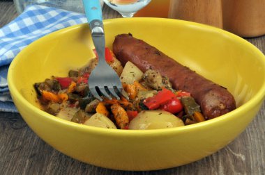 Yakın planda servis edilen patates ve biberli füme sosis.