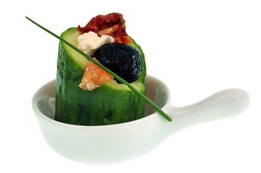 Salatalıklı Amuse bouche, siyah zeytin ve beyaz arkaplanda yakın plan bir tabakta soğan.