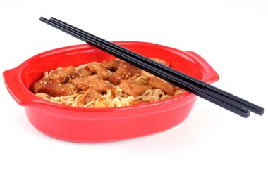 Beyaz arka planda Çin eriştesi, karamelli domuz eti ve Çin yemek çubukları. 