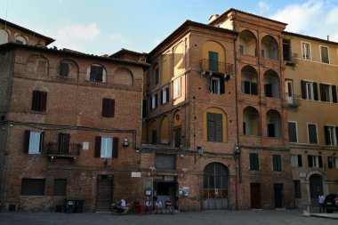 Siena 'nın eteklerindeki Piazza Provenzano' da sandalyede oturan bir grup adam.