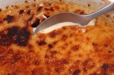Ev yapımı creme brulee kaşık kapaklı bir ramekin içinde