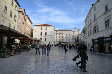 Turistler, Split 'in Narodni Meydanı' nda saat kulesiyle dolaşıyorlar.