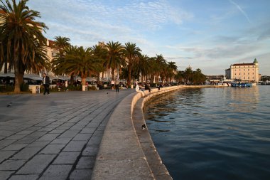 Öğleden sonra Riva rıhtımında gezen ya da dinlenen turistler 