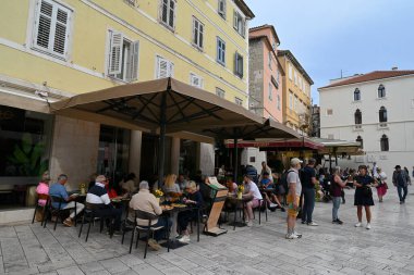 Müşteriler, Split 'teki Narodni Meydanı' ndaki bar ve restoranların teraslarındaki masalarda oturuyordu. 