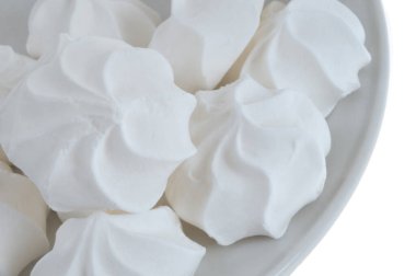 Beyaz arka planda yakın plan bir tabağa yerleştirilmiş kremalar 