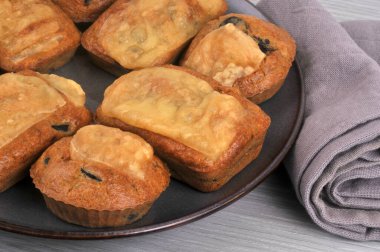 Dikdörtgen ve yuvarlak ev yapımı peynirli kekleri bir tabakta yakın plan.