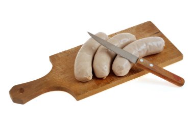 Tahta kesme tahtasındaki beyaz pudingler, yakın plan bıçakla, beyaz arka planda izole edilmiş.