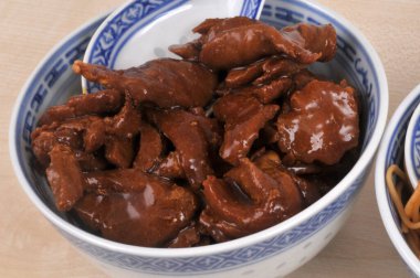 Karamelli domuz eti kasede yakın plan kaşıkla servis edilir.