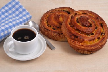 Kuru üzümlü ekmek, ahşap arka planda bir fincan sade kahvenin yanında.