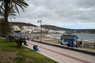 Tenerife 'deki El Camison de Los Cristianos plajındaki turistler bulutlu bir günde