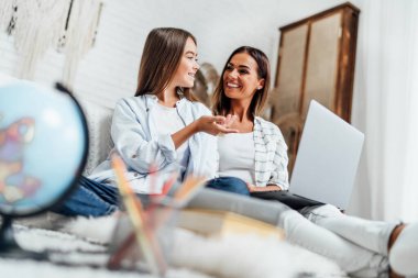 Anne ve kızı ev ödevlerini birlikte çözerler. Uzaklık Öğrenme