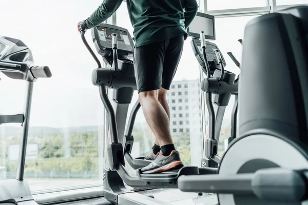 Cornice Ravvicinata Delle Gambe Maschili Sulla Macchina Cardio Palestra Allenamento — Foto Stock