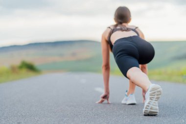 Odaklanılan nokta, koşunun başlamasından önce ayakta duran kızın bacağı. Koşmak için yol, eğitim.