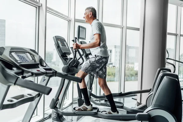 Foto Uomo Anziano Simulatore Che Esegue Cardio Una Palestra Moderna — Foto Stock