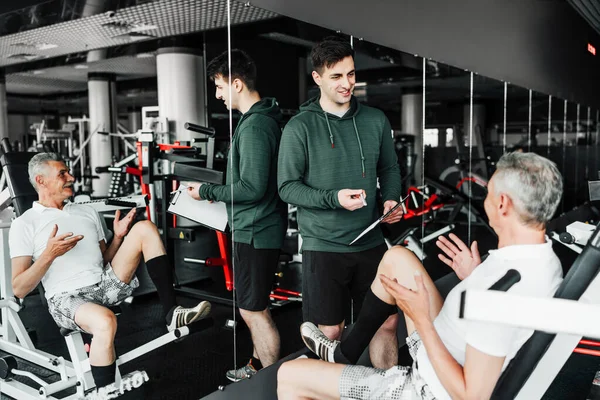 Porträt Zweier Männer Der Turnhalle Einer Von Ihnen Erklärt Einem — Stockfoto