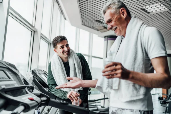 Porträt Zweier Männer Fitnessstudio Die Auf Laufbändern Miteinander Kommunizieren Und — Stockfoto