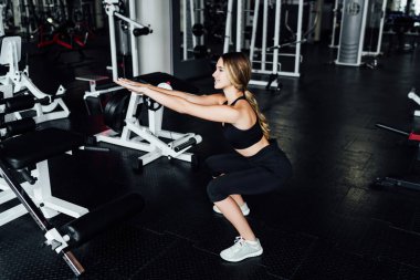 Spor salonundaki çömelme egzersizi sırasında atletik kız, atletik vücut, sağlıklı yaşam tarzı..