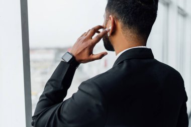 Arap adamın elini kablosuz bir kulaklığa bastırıyor..