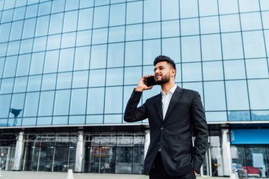 Modern bir bina, önünde iyi bir Hintli yönetici telefonda konuşuyor, bir ofis çalışanı, bir banka çalışanı..
