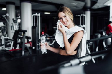 Spor salonunda antrenmandan sonra gülümseyen sarışın kız kameraya gülümsüyor, sağlıklı yaşam tarzı, sağlıklı vücut..