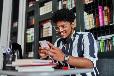 Yakışıklı Hintli bir öğrencinin portresi, öğretmenim, modern akıllı telefonunu kullanıyor. Modern Hint üniversitesi öğretmeni.