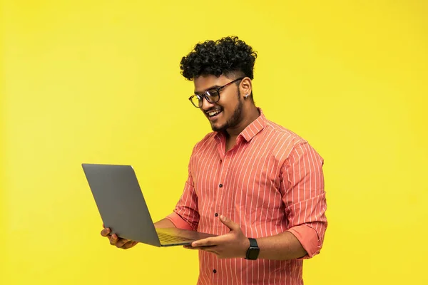 Glimlachende Indiase Man Met Laptop Handen Geïsoleerd Gele Achtergrond Lachend — Stockfoto