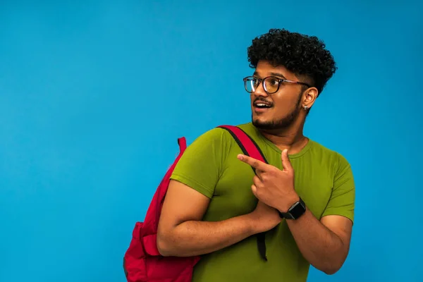 Indiase Student Guy Geïsoleerd Blauwe Achtergrond Met Rugzak Schouders Punten — Stockfoto