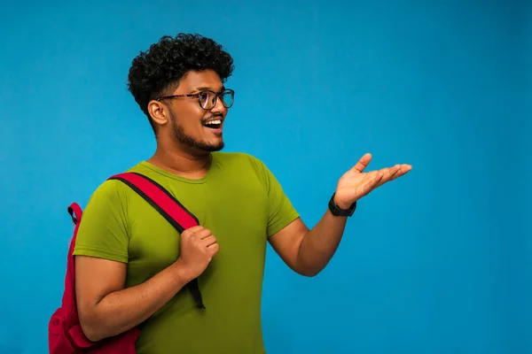 Indiase Student Glimlacht Wijst Naar Universiteit Blauwe Achtergrond Met Plaats — Stockfoto