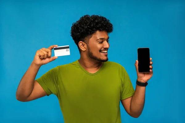 Indio Sonriente Con Una Tarjeta Crédito Mano Smartphone Con Pantalla Imagen De Stock