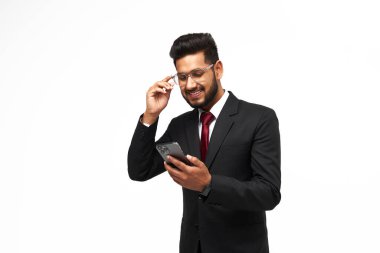 Portrait of young indian manager using his phone on white isolated background