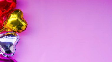 Dört adet altın, kırmızı, pembe ve gümüş renkli şişme kalp seti, pembe arka planda izole edilmiş ve kopyalanmış. Sevgililer günün kutlu olsun, doğum günü partisi konseptin havada aşk