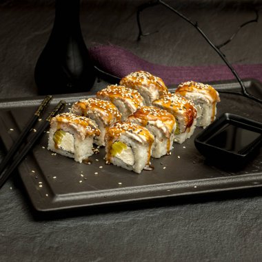 Karanlık bir arka planda iştah açıcı suşi.