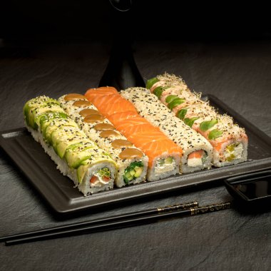 Karanlık bir arka planda iştah açıcı suşi.