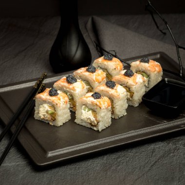 Karanlık bir arka planda iştah açıcı suşi.