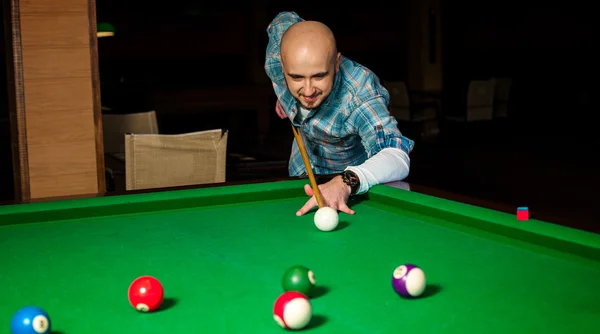 Hombre concentrado tratar de golpear la bola blanca en la mesa de billar — Foto de Stock