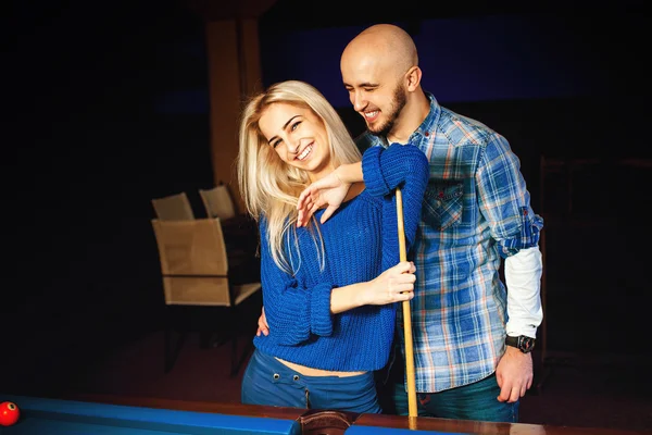 Fashionable couple having fun and plays billiard — Stock Photo, Image