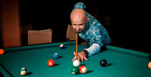 Retrato horizontal de homem concentrado joga em mesa de bilhar — Fotografia de Stock