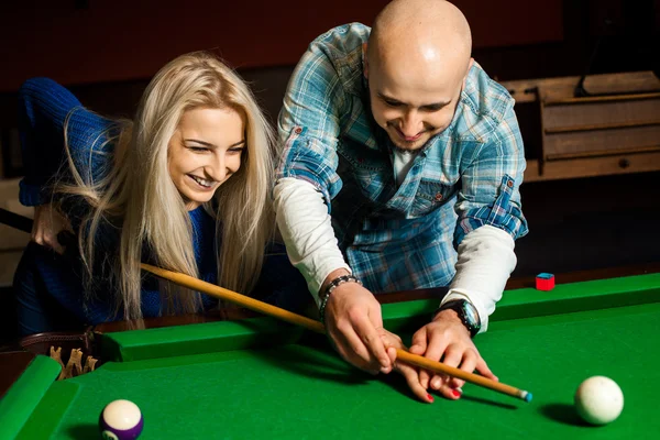 Homem ensina sua namorada a jogar na mesa de bilhar — Fotografia de Stock