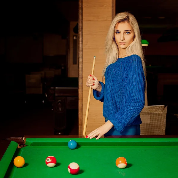 Pretty blonde woman with blue eyes plays billiard — Stock Photo, Image