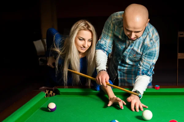 Teacher shows a girl how to play pool billiard — Stock Photo, Image