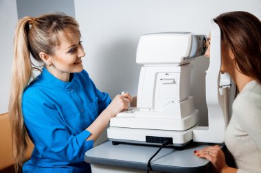 bir sigara mydriatic retina kullanarak bir genç güzel göz doktoru 