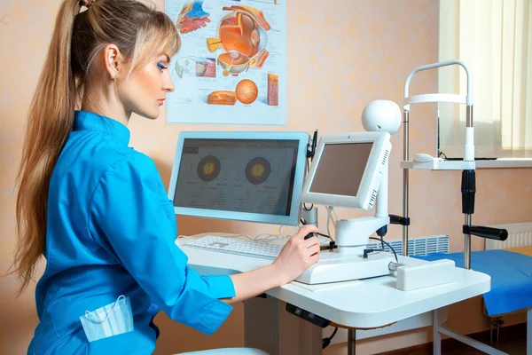 Mladý ženský lékař pracující na počítači v kabinetu — Stock fotografie