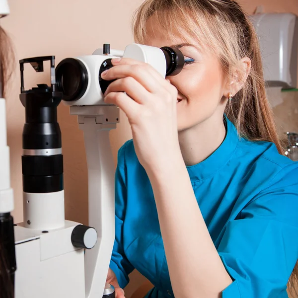 Feliz joven Doctor optometrista en el trabajo con el dispositivo para testi —  Fotos de Stock