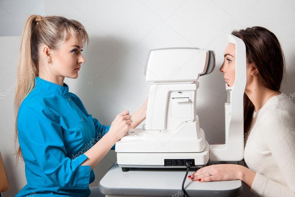 Ophthalmologist woman In Exam Room With Young beautiful brunette